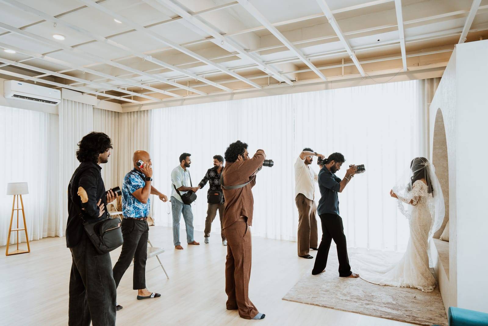 Behind the scenes: crew photographing a bride on the Lumen floor at Veedo studio, Kochi