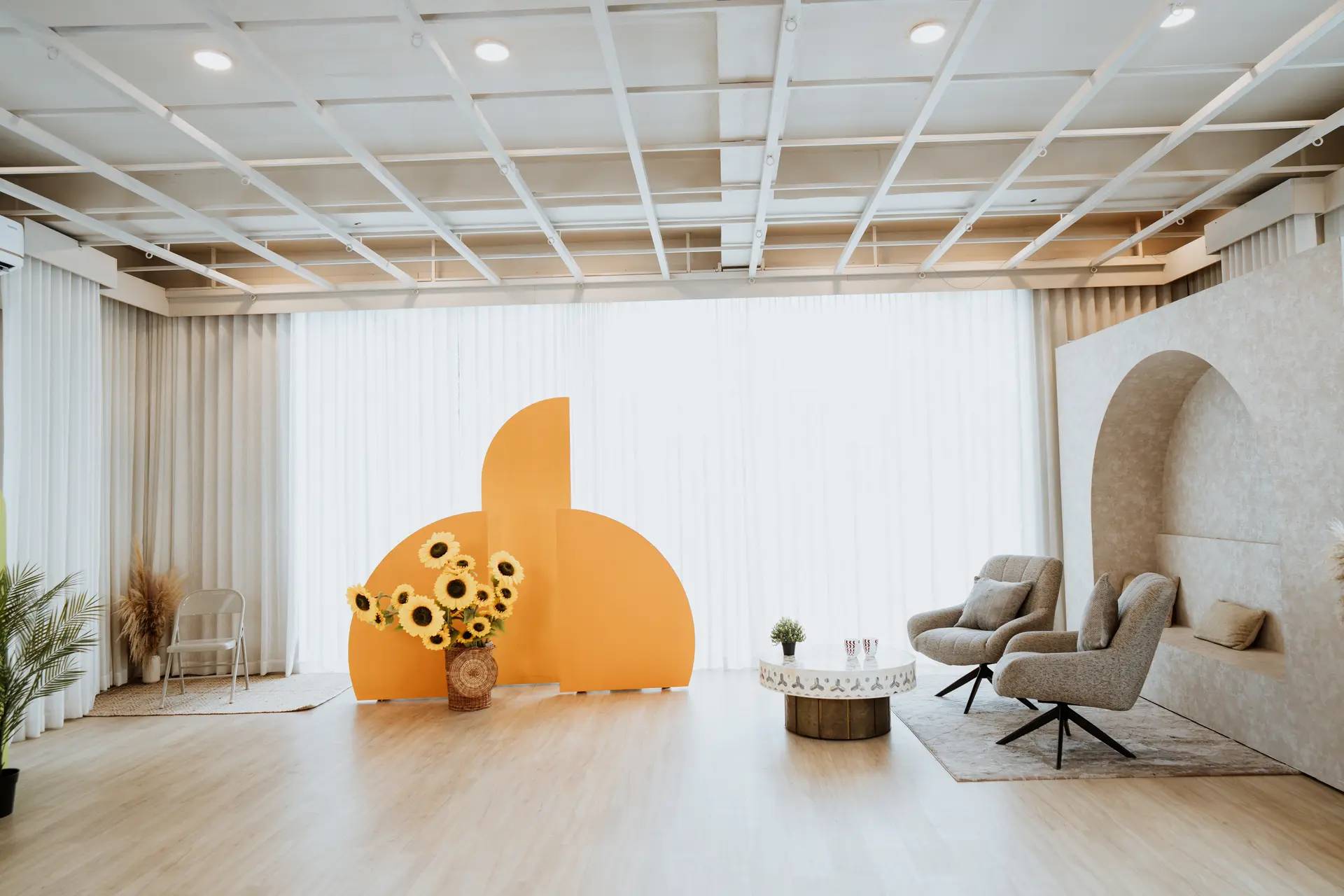 White studio floor with arch and sofa setups at Veedo Lumen, Kochi
